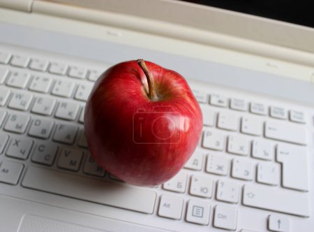 Téléchargez les photos : Boutons flous du clavier blanc avec des fruits rouges juteux de pomme dessus - en image libre de droit
