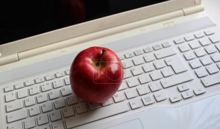 Téléchargez les photos : Pomme rouge sur un clavier d'ordinateur blanc avec des caractères latins seulement photo en stock - en image libre de droit