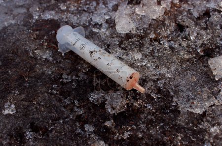 Téléchargez les photos : Seringue ensanglantée jetée par un toxicomane après une injection - en image libre de droit