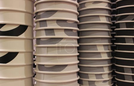 Painted paper cups lined up in columns arranged by color for coffee of different strengths