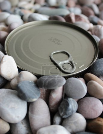 Foto de La tapa superior de la lata a largo plazo con la llave está enterrada en pequeños guijarros - Imagen libre de derechos