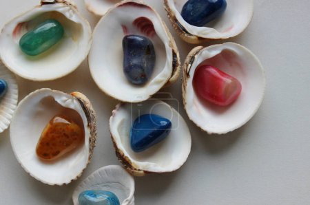 Foto de Montón de conchas de almejas a la mitad con una piedra de vidrio de color en el interior sobre fondo blanco limpio - Imagen libre de derechos