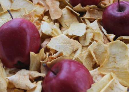 Téléchargez les photos : Ingrédients pour la compote de fruits secs. Vue détaillée des pommes rouges crues saupoudrées de tranches de pommes déshydratées - en image libre de droit