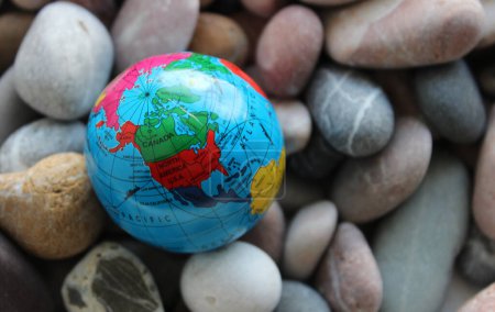 Globo en miniatura con una imagen visible de los EE.UU. y Canadá en pequeñas rocas de mar redondas