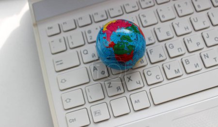 Blick von oben auf den Nordpol, Ozeane und Teile von Kontinenten auf einer weißen zweisprachigen Laptop-Tastatur 