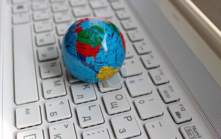 Miniature Globe With A Visible Image Of The USA and Canada Lying On White Desktop Bilingual Keypad