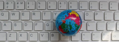 Globus-Modell auf Computertastatur mit nur lateinischen Buchstaben von oben 