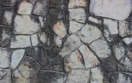 Granite stones darkened with time and placed in old masonry