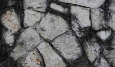 Smooth edges of stones in ancient wall texture background 