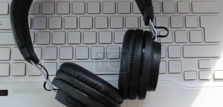 Black Headphones On White Blank Keys Of Computer Keyboard