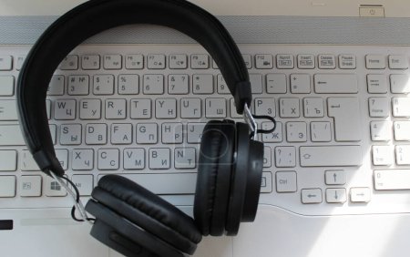 Modern Headphones Lying On Bilingual Keyboard. Concept Stock Image For International Music Backgrounds   
