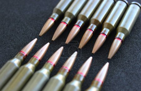 Bullets lined up with heads to heads on black silk velvet surface angle view