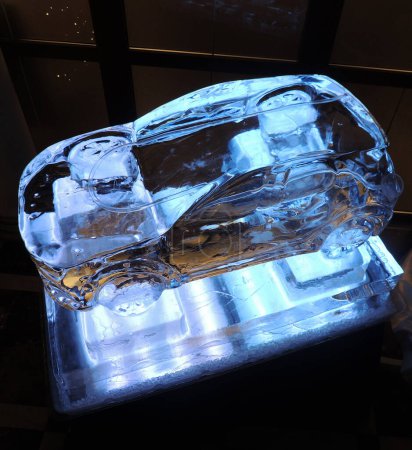 Vista superior de un modelo de coche transparente de pie en un soporte con luz de fondo azul