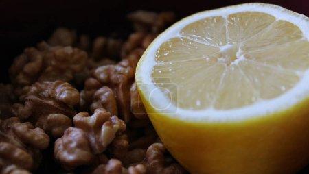 Juicy Lemon Cut In Half On Peeled Walnuts Side View Stock Photo For Healthy Food Illustration