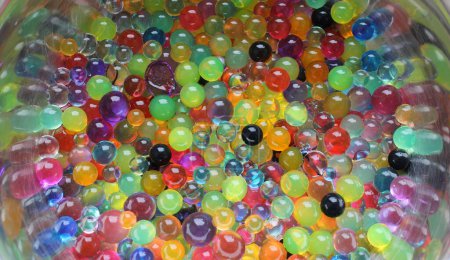 Montón de bolas de agua multicolor en la superficie de acero curvado 