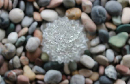 Cristal clair en forme de fleur sur les cailloux colorés Top View Stock Photo Pour Pierres milieux
