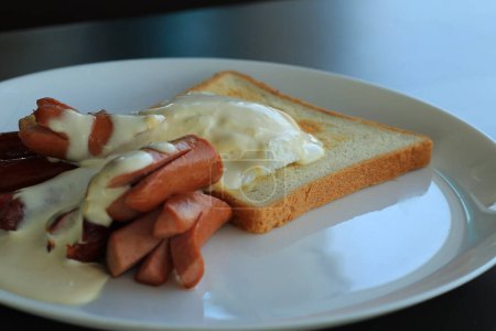 Photo for Fried frankfurters, shirred eggs and hot toast setting for hearty breakfast - Royalty Free Image