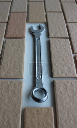 Hex Head Spanner On Free Space In Surface Covered Brick Tiles. Home Renovation Stock Photo For Vertical Story