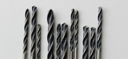 Perceuses en métal noir sur feuille de plastique blanc en forme de code à barres 