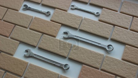 Combination Spanners Inside Decorative Brickwork Closeup Angle View. Stock Photo For Home Work And Renovation Illustration