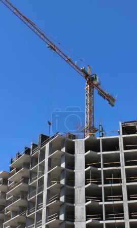 Turmdrehkran über Betonrahmen des Neubaus  