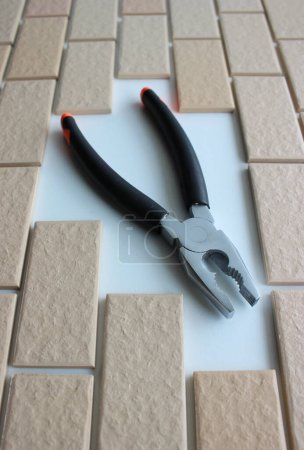 Combination Pliers Inside Decorative Brickwork Closeup Angle View. Stock Photo For Repairing Illustration