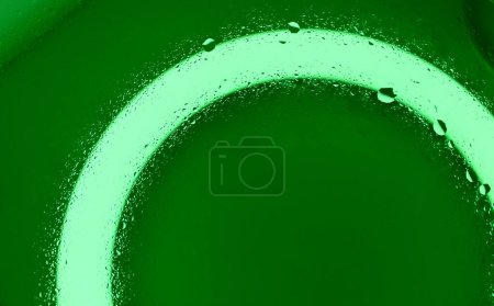 Agua espolvoreada sobre vidrio limpio en luz verde Foto de stock detallada 