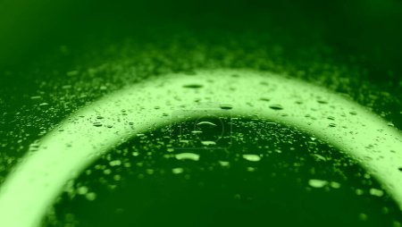Tropfenmuster auf nassem Glas mit intensiver grüner Hintergrundbeleuchtung. Green Screen Droplet Archivfoto