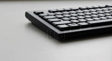 Ein Teil der schwarzen Desktop-Tastatur auf weißem Tisch Winkel Ansicht Nahaufnahme Archivfoto 