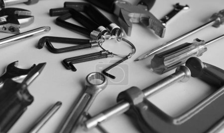 Photo for Grayscale Image Of Home Repair Tools On White Table Detailed View. Home Work And Repair Equipment Stock Photo - Royalty Free Image