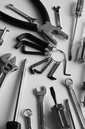 Photo for Vertical Stock Image Of Scattered Monochrome Carpentry Tools On Clean White Table - Royalty Free Image