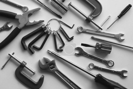 Photo for Chaotically scattered hand tools on a white shelf. Monochrome stock photo for repairing backgrounds - Royalty Free Image