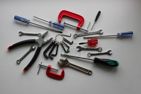 Photo for Chaotically scattered colored hand tools on a white shelf. Stock photo for DIY and repairing illustration - Royalty Free Image