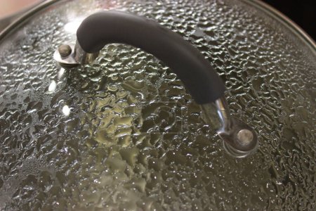 Gotas de vapor en la parte interna de la sartén de vidrio caliente en proceso de ebullición