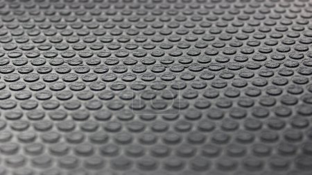 Round elements on a rubberized insulation sheet with blurred top and bottom edges. Rubber texture stock photo