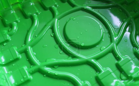 Kondenswasser fällt auf einen Boden aus grünem Plastiktablett mit geschwungenen Linien und Kreismuster Nahaufnahme 