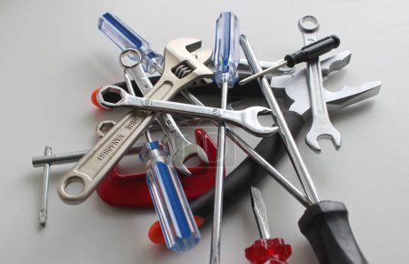 Heap Of Variety Colored Repairing Tools On White Surface Closeup View. Home Work And Repair Equipment Stock Photo 