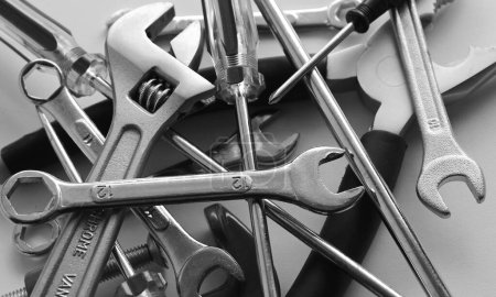 Photo for Scattered Mechanic Tools With Black Handles Isolated On White Surface. Grayscale Stock Photo For Tools Backgrounds - Royalty Free Image
