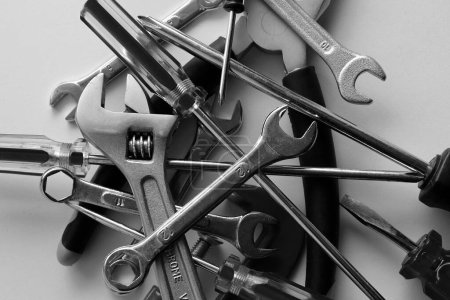 Photo for Variety scattered hand tools on a white shelf. Monochrome stock photo for repairing backgrounds - Royalty Free Image