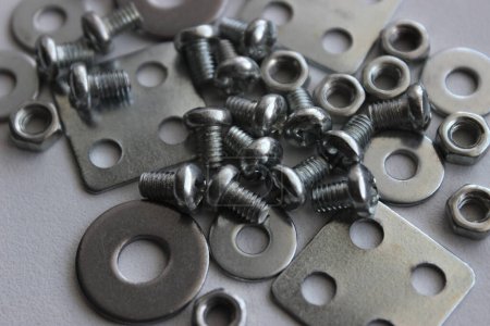 Mix Of Metal Steel Screw Items Scattered On White Surface Macro Shot Stock Photo. Hardware And Fasteners Royalty Free Background