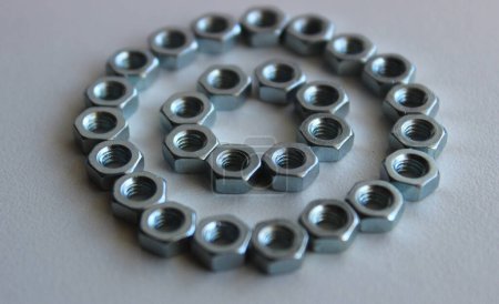 Parte del patrón de círculo arreglado con tuercas hexagonales aisladas en blanco cuadrado Stock Photo