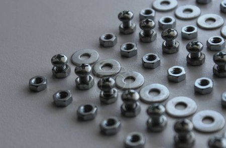 Sujetador de acero metálico y piezas de fijación en líneas pares en la superficie plástica Foto de stock detallada. Ironware Goods Fondo libre de regalías
