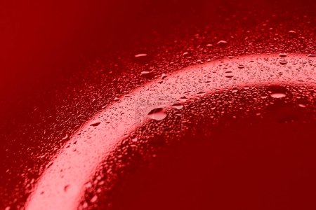 Tröpfchenmuster auf rot beleuchteter Glasoberfläche. Archivfoto zur Illustration von Blutkörperchen 