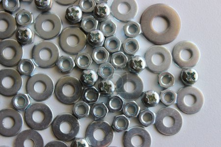 Variety Metallic Color Fasteners And Screw Products Scattered On White Surface At A Side Of Image. Nuts And Bolts Hardware Royalty Free Background