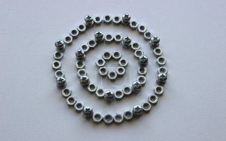 Mechanical Circle Pattern Of Metallic Color Nuts And Injected Bolts Isolated On Plastic Surface Top View