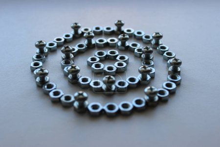 Rings made of steel color nuts and bolts screwed into them at regular intervals angle view stock photo for mechanical backgrounds