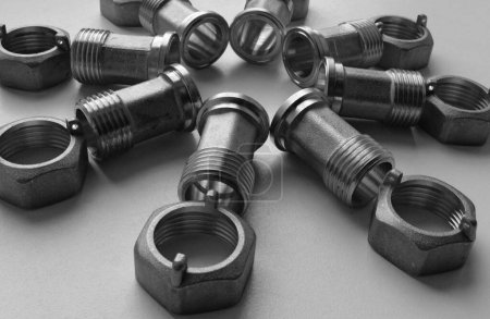 Cast Iron Sanitary And Tubing Accessories. Joint Fittings And Plumbing Nuts Laid Out In Star Shape On White Angle View Stock Photo