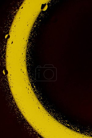 Sorte Tropfen und Spritzer auf sauberer Oberfläche im goldenen Licht Archivfoto