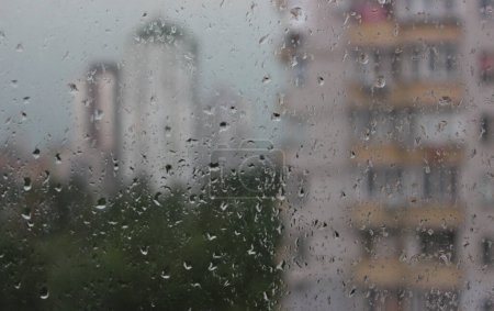 Regentropfen auf ein Fenster eines mehrstöckigen Gebäudes Archivbild