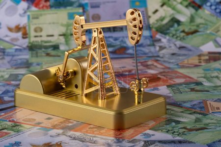 Oil pump against the background of Kazakh banknotes (tenge)